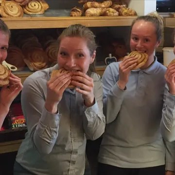 Kafe og personalet med Jeanett spiser kanelbolle