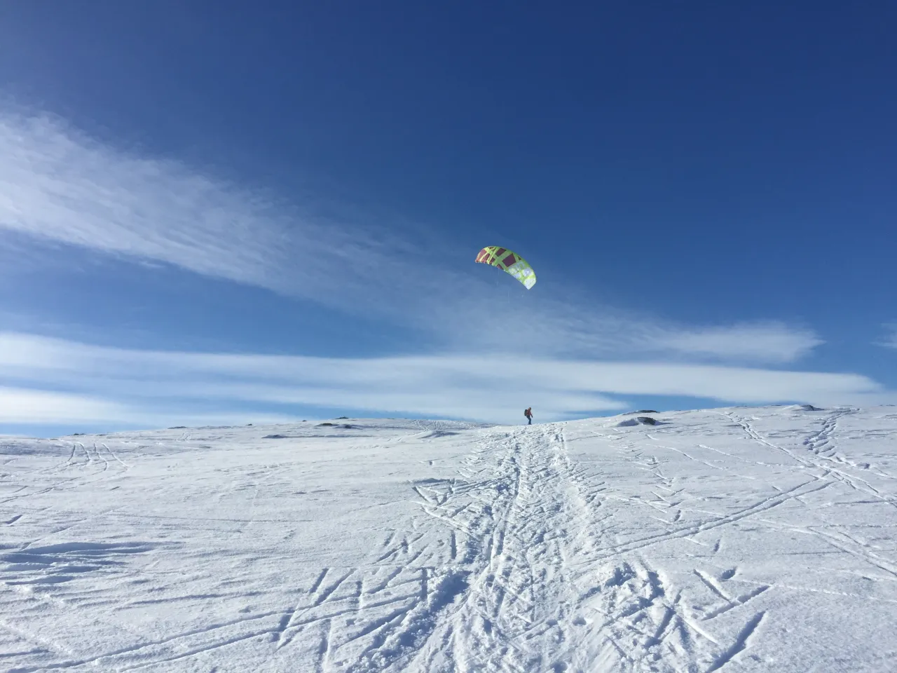 en person som kiter på en snødekt bakke